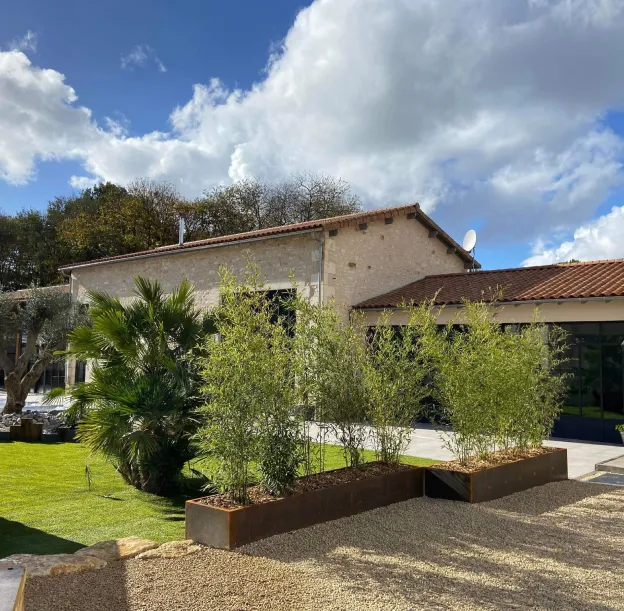 jardins avec massif de bambou et palmier à Azay-le-Brûlé près de Saint-Maixent-L'Ecole dans les Deux-Sèvres 79